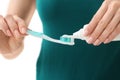 Young woman squeezing toothpaste on brush, closeup Royalty Free Stock Photo