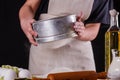 Young woman squirting a flour in an apron