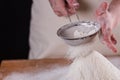 Young woman squirting a flour in an apron