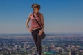 Young woman staing on the hill with city view, Almaty, Kazakhstan