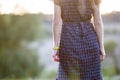 Young woman standing alone on a field with green grass enjoying warm sunset Royalty Free Stock Photo