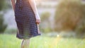 Young woman standing alone on a field with green grass enjoying warm sunset Royalty Free Stock Photo