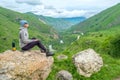 Young woman standing with a backpack in a mountain valley.