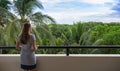 Young woman standing on the balcony and looking at her view of a tropical jungle nature outdoor during a vacation in Mexico Royalty Free Stock Photo