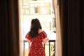 Young woman is standing on balcony and looking out Royalty Free Stock Photo