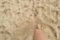 A young woman standing barefoot on the sand on a Sunny summer day. Top view of a beautiful leg. Empty space for text Royalty Free Stock Photo