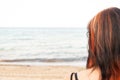 Young woman standing at the beach, looking at the sea Royalty Free Stock Photo