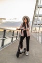 A young woman standing on the bridge next to her electric scooter Royalty Free Stock Photo