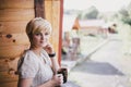 Young woman standing on the cozy balcony with a cup of tea