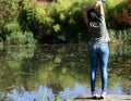 Young woman standing on the edge of a lake