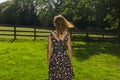 Young woman standing in field by fence on summer day Royalty Free Stock Photo