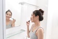 A young woman is standing in front of the bathroom mirror and putting on makeup Royalty Free Stock Photo
