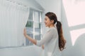 Young woman standing in front of the bedroom window looking outside Royalty Free Stock Photo