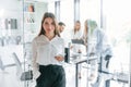 Young woman standing in front of her colleagues. A group of professional business people is in the office Royalty Free Stock Photo