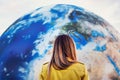 Young woman standing in front of large inflatable model of planet Earth, detail on Europe northern Africa, Middle east, view form