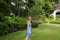 Young woman standing on green grass near resort house. Royalty Free Stock Photo