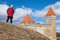 Young woman standing on hill agaist towers of the Kuressaare Episcopal Castle. The Kuressaare ciy, Saaremaa island, Estonia Royalty Free Stock Photo