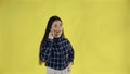 Young woman standing isolated over yellow background while talking by phone Royalty Free Stock Photo