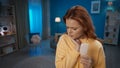 A young woman is standing in the living room holding her cheek close up. Woman suffering from toothache after biting off Royalty Free Stock Photo