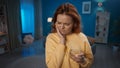 A young woman is standing in the living room holding her cheek close up. A woman suffers from toothache after drinking Royalty Free Stock Photo