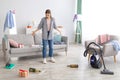 Young woman standing in messy apartment after party, screaming from despair, empty space