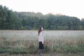 Young woman standing in a misty field in the morning. Autumn morning and sunrise on a misty field. Royalty Free Stock Photo