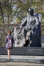 Young woman standing near Chopin statue