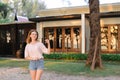 Young woman standing near resort house and keeping keys. Royalty Free Stock Photo