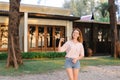 Young woman standing near resort house and keeping keys. Royalty Free Stock Photo