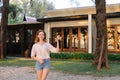 Young woman standing near resort house and keeping keys. Royalty Free Stock Photo