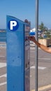 Young woman standing next to parking machine and paying for parking Royalty Free Stock Photo