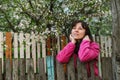 Young woman standing by old fence and dreamy looking Royalty Free Stock Photo