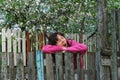 Young woman standing by old fence and yawn Royalty Free Stock Photo