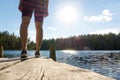 Young woman standing on an old wooden dock and pier at a lake. Royalty Free Stock Photo