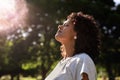 Young woman standing outdoors feeling the sun on her face Royalty Free Stock Photo