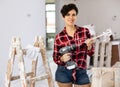 Young woman standing with paint mixer in hands during apartment renovation Royalty Free Stock Photo