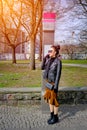 Young woman standing at phonebox in daylight