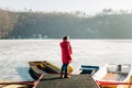 Young woman standing on the pier of a frozen lake Royalty Free Stock Photo