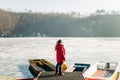 Young woman standing on the pier of a frozen lake Royalty Free Stock Photo