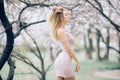 A young woman is standing, relaxing and enjoying the spring flowering garden Royalty Free Stock Photo
