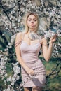 A young woman is standing, relaxing and enjoying the spring flowering garden Royalty Free Stock Photo