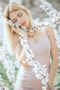 A young woman is standing, relaxing and enjoying the spring flowering garden Royalty Free Stock Photo