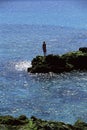 Young woman standing rocks, looking out to sea Royalty Free Stock Photo