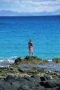 Young woman standing rocks, looking out to sea Royalty Free Stock Photo