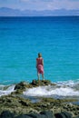 Young woman standing rocks, looking out to sea Royalty Free Stock Photo