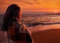 Woman enjoying view of sunset on beach. Royalty Free Stock Photo