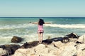 Young woman standing on a sea beach enjoying the beautiful sunny weather Royalty Free Stock Photo