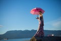 Young woman standing sea shore umbrella sunny day Royalty Free Stock Photo
