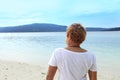 A young woman standing by the sea with sea view. Royalty Free Stock Photo