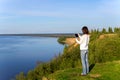 Young woman standing on the shore of the lake with tablet comput Royalty Free Stock Photo